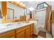 Bright bathroom features a wood framed mirror, cabinets and a skylight over the shower/bath at 1959 Grand Prix Ne Dr, Atlanta, GA 30345