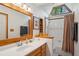 Bright bathroom with wooden vanity, framed mirror and natural light from trapezoid window at 1959 Grand Prix Ne Dr, Atlanta, GA 30345