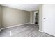 Unfurnished bedroom featuring neutral walls, wood-look floors, a white door, and an ensuite bathroom for convenience at 845 Regal Path Ln, Decatur, GA 30030