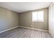 Bedroom featuring neutral walls, wood-look floors, a window, and a closet with paneled doors, creating a cozy retreat at 845 Regal Path Ln, Decatur, GA 30030