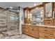 Elegant bathroom featuring frameless glass shower, wooden cabinets with granite countertops, and herringbone tile floors at 1233 Poplar Grove Ne Dr, Atlanta, GA 30306
