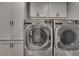 Convenient laundry room features modern washer and dryer, complemented by ample storage cabinets at 1233 Poplar Grove Ne Dr, Atlanta, GA 30306
