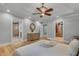 Comfortable main bedroom featuring tray ceilings, decorative ceiling fan, hardwood floors, and a view into the bathroom and closet at 1233 Poplar Grove Ne Dr, Atlanta, GA 30306