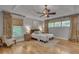 Serene main bedroom featuring hardwood floors, tray ceiling, ceiling fan, decorative curtains, and natural light at 1233 Poplar Grove Ne Dr, Atlanta, GA 30306