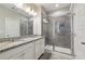Bathroom featuring granite countertops with double sinks, vanity, and a tiled walk-in shower, creating a practical space at 1829 Hislop Ln, Atlanta, GA 30345