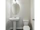 Neat powder room featuring an oval mirror, pedestal sink, and a matching toilet, providing a convenient space at 1829 Hislop Ln, Atlanta, GA 30345