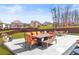 Outdoor seating area with chairs and table on a concrete patio in a landscaped backyard with lawn and fence at 3314 Ridge Manor Way, Dacula, GA 30019