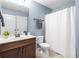 Bright bathroom featuring a white shower curtain, toilet, vanity, and blue painted walls at 3314 Ridge Manor Way, Dacula, GA 30019