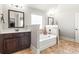 Well-lit bathroom featuring a soaking tub, tiled backsplash, and wood vanity at 3314 Ridge Manor Way, Dacula, GA 30019