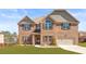 Charming two-story brick home featuring a well-maintained lawn, arched window, and attached garage at 3314 Ridge Manor Way, Dacula, GA 30019