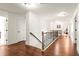Bright hallway with hardwood floors, white walls, and staircase with decorative iron railing at 3314 Ridge Manor Way, Dacula, GA 30019