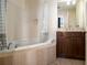 Bathroom with tiled walls and floors, a jetted tub, and vanity at 57 Forsyth Nw St # 16D, Atlanta, GA 30303