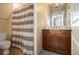 Cozy bathroom with shower featuring a striped curtain and a vanity with wooden cabinets at 57 Forsyth Nw St # 16D, Atlanta, GA 30303