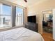 Bright bedroom featuring a large window with city views, a TV, and hardwood floors at 57 Forsyth Nw St # 16D, Atlanta, GA 30303