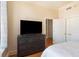 A bedroom with a large screen TV, a dresser, and two closet doors at 57 Forsyth Nw St # 16D, Atlanta, GA 30303