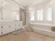Bright bathroom featuring a tub, white cabinets and mirror at 8531 N Shore Dr, Jonesboro, GA 30236