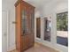 Entryway featuring a glass paneled storage cabinet, a door to the garage, and two windows overlooking the drive at 8531 N Shore Dr, Jonesboro, GA 30236