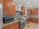 Well-equipped kitchen featuring stainless steel appliances, granite countertops, and wooden cabinets at 8531 N Shore Dr, Jonesboro, GA 30236