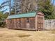 Exterior shot of the large wooden storage shed with a green metal roof in the backyard at 8531 N Shore Dr, Jonesboro, GA 30236