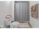 Well-lit bathroom with a toilet, shower with neutral curtain, and stacked clean towels on the commode at 170 Boulevard Se # H428, Atlanta, GA 30312