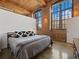 Bedroom with exposed brick walls, wood ceilings, and large windows that provide ample natural light at 170 Boulevard Se # H428, Atlanta, GA 30312
