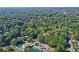 A bird's-eye view shows a neighborhood nestled among lush green trees and community tennis and swimming amenities at 4184 Westchester Ne Trce, Roswell, GA 30075