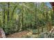 Wooded backyard with mature trees and landscaping including stone steps and handrail at 4184 Westchester Ne Trce, Roswell, GA 30075