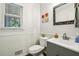 Updated half bath with a modern vanity, paneled walls, and a window at 4184 Westchester Ne Trce, Roswell, GA 30075
