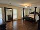Spacious bedroom featuring a four-poster bed, hardwood floors, and a large mirror at 4184 Westchester Ne Trce, Roswell, GA 30075