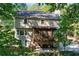 Exterior view of two story home with backyard porch and patio surrounded by trees at 4184 Westchester Ne Trce, Roswell, GA 30075