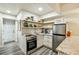 Compact kitchen features stainless steel appliances, light wood shelves and countertops, and gray wood-look floors at 4184 Westchester Ne Trce, Roswell, GA 30075