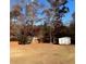 Large backyard with storage shed surrounded by mature trees and a wooden fence at 501 Owens Springs Ln, Mcdonough, GA 30252