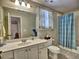 Well-lit bathroom featuring a vanity with sink, toilet, and shower with blue curtains at 112 Estates At The Lake Dr, Canton, GA 30114