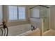Relaxing bathroom featuring a soaking tub, separate glass shower, and neutral tile at 112 Estates At The Lake Dr, Canton, GA 30114