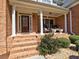 Inviting front porch with rocking chairs and elegant brickwork at 112 Estates At The Lake Dr, Canton, GA 30114