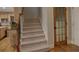 Carpeted staircase leading upwards with a wooden door and trim accents at 112 Estates At The Lake Dr, Canton, GA 30114