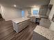 Modern kitchen featuring an island with granite countertops, gray cabinets, and hardwood flooring at 116 Deer Xing, Temple, GA 30179