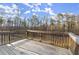 Deck with a wood railing and the blue sky and trees visible from the backyard at 411 Spring Lake Hls, White, GA 30184