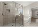 Bright bathroom featuring glass enclosed shower with seat, soaking tub, and beige tile throughout at 411 Spring Lake Hls, White, GA 30184