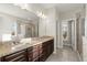 Bathroom with granite counters, double sinks, a large mirror, tiled floors, and a glass enclosed shower at 411 Spring Lake Hls, White, GA 30184