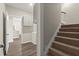 Hallway with stairway, laundry room, and wood style flooring creating a seamless transition throughout the home at 411 Spring Lake Hls, White, GA 30184