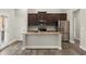 The kitchen features stainless steel appliances, hardwood floors, and a center island at 411 Spring Lake Hls, White, GA 30184