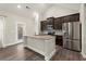 An eat-in kitchen features stainless steel appliances, hardwood floors, and a center island at 411 Spring Lake Hls, White, GA 30184
