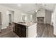 Kitchen with dark wood cabinets and center island opening up to the living room with stone fireplace at 411 Spring Lake Hls, White, GA 30184