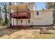 Backyard view of a white two-story home with a red deck, grass, and blue sky at 4620 Central Dr, Stone Mountain, GA 30083