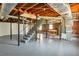 Unfinished basement with concrete floor, exposed ductwork, support beams, and a staircase leading upstairs at 4620 Central Dr, Stone Mountain, GA 30083