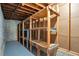 Unfinished basement with concrete floor, exposed ceiling with ductwork, and built-in wooden shelving at 4620 Central Dr, Stone Mountain, GA 30083