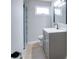 Modern bathroom with gray vanity, tile floors, and a glass-enclosed shower with tile surround at 4620 Central Dr, Stone Mountain, GA 30083