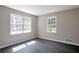 Bright bedroom featuring two windows, gray walls, and sleek gray hardwood floors at 4620 Central Dr, Stone Mountain, GA 30083