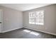 Cozy bedroom with a bright white window, gray walls, and sleek gray hardwood floors at 4620 Central Dr, Stone Mountain, GA 30083
